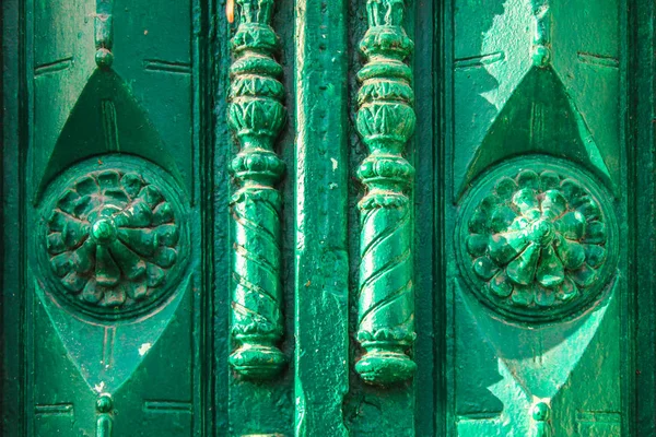 An antique vintage green wooden door with carved elements on a sunny day. — Stock Photo, Image