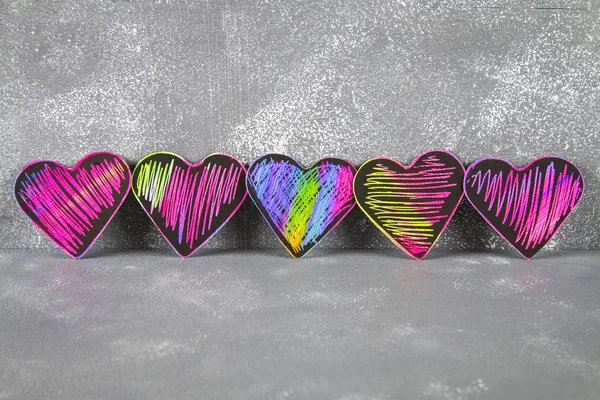 Homemade Black violet pink hearts on a gray concrete background. The concept of Valentine\'s Day. A symbol of love.