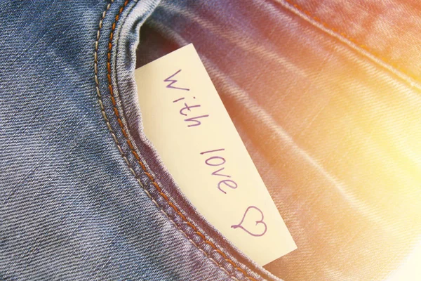 Zettel mit der Aufschrift i love you, mit Liebe lugt aus der Hosentasche der Jeans hervor. das Konzept des Tages der Liebenden. Valentinstag. — Stockfoto