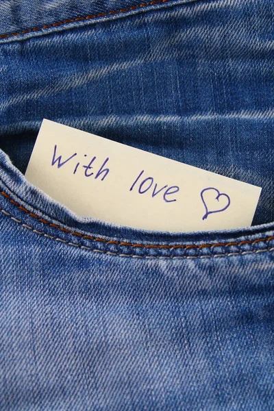 Zettel mit der Aufschrift i love you, mit Liebe lugt aus der Hosentasche der Jeans hervor. das Konzept des Tages der Liebenden. Valentinstag. — Stockfoto