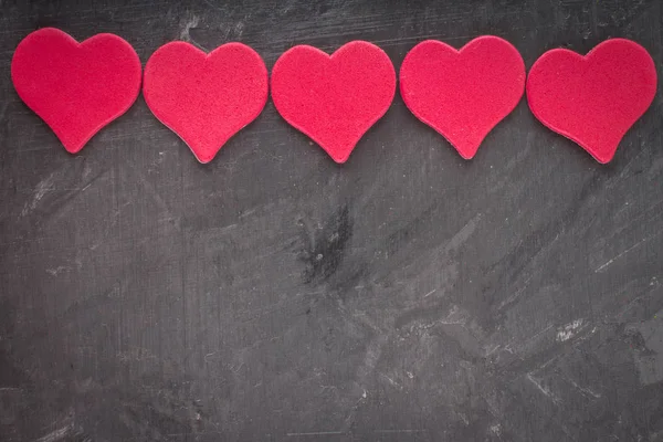 Rosa hjärtan på en grå bakgrund. Symbolen för dagen för älskare — Stockfoto