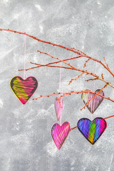 Black-pink hearts hang on branches on a gray concrete background. Love tree. The concept of Valentine's Day. A symbol of love. — Stock Photo, Image