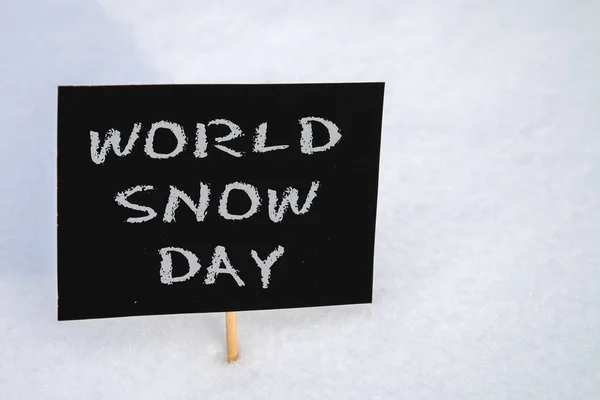 Kreidetafel im Schnee mit der Aufschrift - Weltschneetag. — Stockfoto