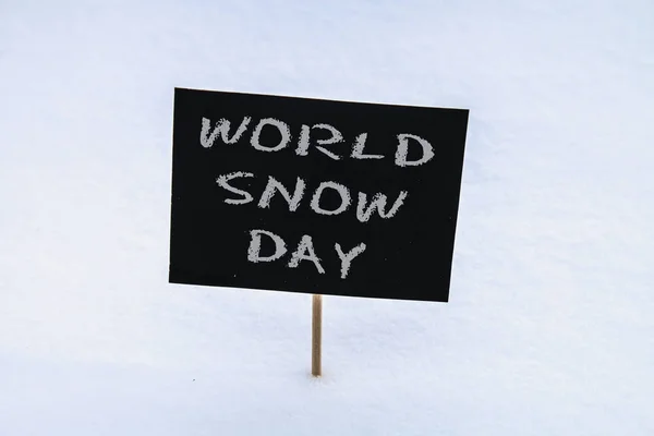 Kreidetafel im Schnee mit der Aufschrift - Weltschneetag. — Stockfoto