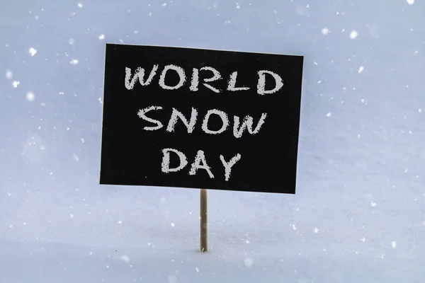 Kreidetafel im Schnee mit der Aufschrift - Weltschneetag. — Stockfoto