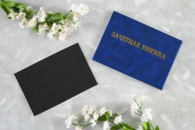 Mavi kitap ile bir yazıt Rusça - bir öğrencinin kayıt defteri. Gri bir arka plan üzerinde beyaz çiçekler. Öğrencilerin gün. Tatyana'nın günü. Kopyalama alanı.
