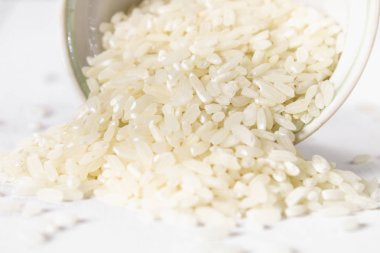 Kurulların Beyaz ahşap bir masa üzerinde çiğ beyaz pirinç taneleri. Yemek pişirmek için malzemeler.