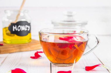 Çiçek siyah çay, bal olabilir, bir beyaz tahta masada yaprakları.