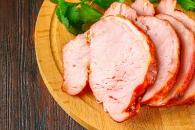 Salantro ile kahverengi ahşap bir masa üzerinde domuz Loin kızartma dilimlenmiş.