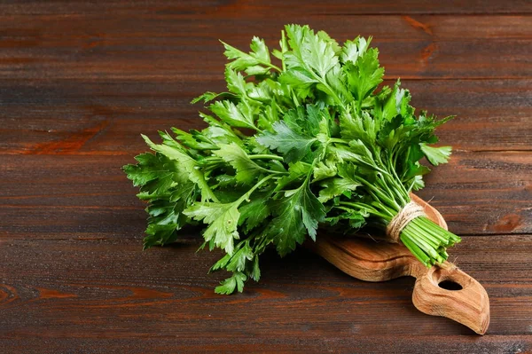 Bir demet ahşap bir masa üzerinde yeşil maydanoz.