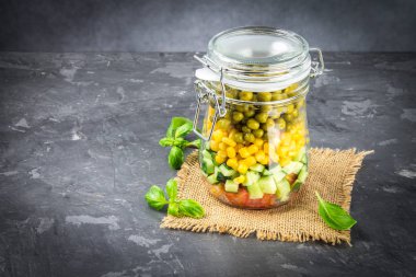 Sağlıklı ev yapımı salata sebze, salatalık, domates, bezelye ve Mısır - sağlıklı diyet, Detoks, saf gıda veya vejetaryen kavramı ile bir kavanoz içinde.
