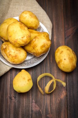 Çiğ patates kahverengi ahşap arka plan üzerinde.