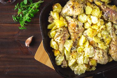 Kimyon ve sarımsak ile patates ile kavrulmuş tavuk budu.