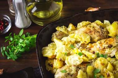 Kimyon ve sarımsak ile patates ile kavrulmuş tavuk budu.