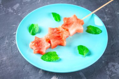 Karpuz nane yaprakları ile şiş üzerinde yıldız şeklinde bir mavi plaka üzerinde yatıyor. Üstten Görünüm.