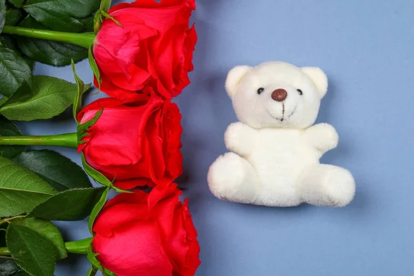White teddy bear surrounded by pink roses on a grey table. Template for March 8, Mother's Day, Valentine's Day. — Stock Photo, Image
