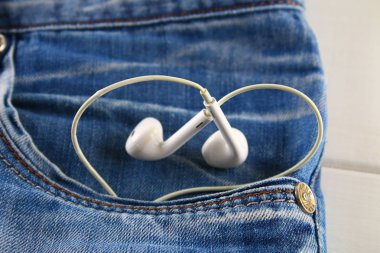 Kalp beyaz kulaklık - aşk bir sembolü kot pantolon cebinden peeps. Aşk için müzik. Sevgililer günü kavramı. St. Valentine's Day.