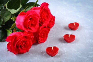 Pembe Gül gri bir arka plan üzerinde bir kalp şeklinde kırmızı mumlar ile. Şablon için 8 Mart, anneler günü, Sevgililer günü.