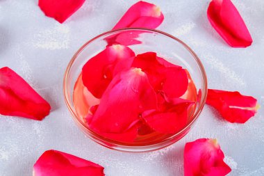 Gül yaprakları gri bir tablo üzerinde pembe su. Spa.