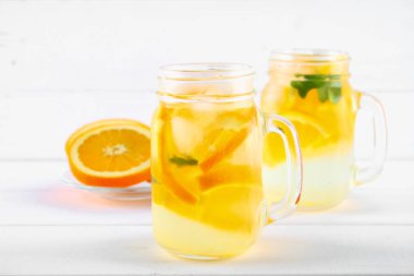 Turuncu Detoks su mason kavanoz bir beyaz tahta masada. Sağlıklı gıda, içecekler.