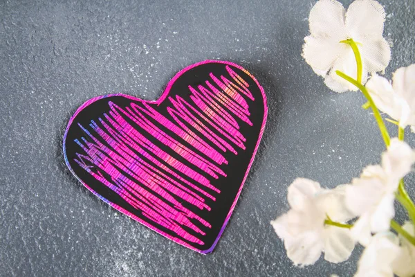 Homemade Black violet pink hearts on a gray concrete background. The concept of Valentine\'s Day. A symbol of love.