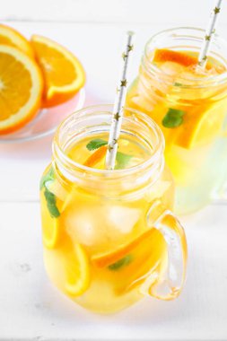 Turuncu Detoks su mason kavanoz bir beyaz tahta masada. Sağlıklı gıda, içecekler.