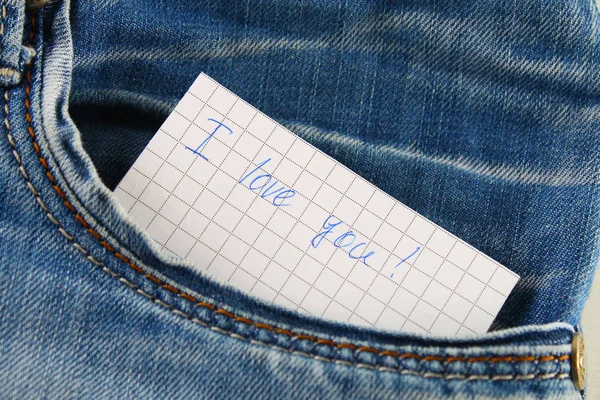 Zettel mit der Aufschrift i love you, mit Liebe lugt aus der Hosentasche der Jeans hervor. das Konzept des Tages der Liebenden. Valentinstag. — Stockfoto