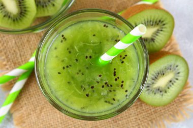 Dilimlenmiş kivi ve güler yüzlü dilimleri bir cam gri bir tablo. Sağlıklı gıda.