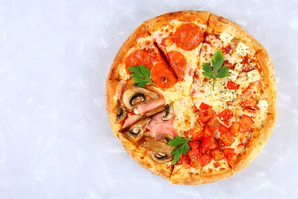 Pizza z pepperoni, pieczarki, pomidor i serem. Cztery smaki w jednej pizzy. Szary beton tabeli. — Zdjęcie stockowe