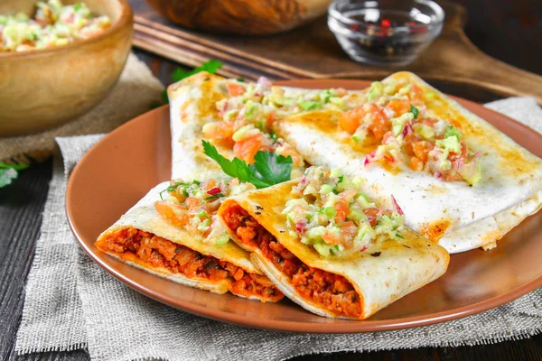 Traditionele Mexicaanse schotel - chimichanga. Maïs taart met gehakt, paprika, ui, knoflook, oregano, zira en guacomole saus van avocado. — Stockfoto