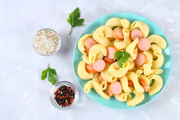 Pasta Cavatappi or Cellentani with sausages on a gray table. — Stock Photo, Image