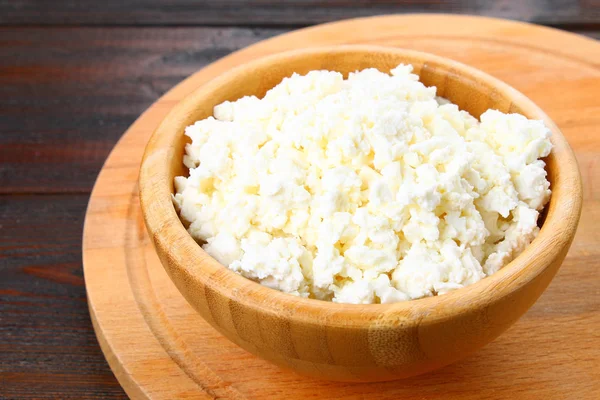 Hüttenkäse in einer Schüssel auf einem Holztisch. — Stockfoto