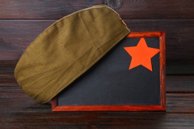 Boş alanı, askeri kap ve ahşap bir masa üzerinde kırmızı yıldız ile kara tahta. Gün vatan ve 9 Mayıs savunucusu.