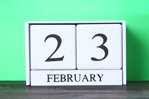 White wooden perpetual calendar with the date of February 23 on