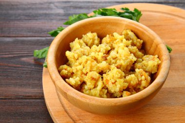 Pirinç pilavı tavuk, baharat ve maydanoz ahşap bir masa üzerinde bir kase ile.