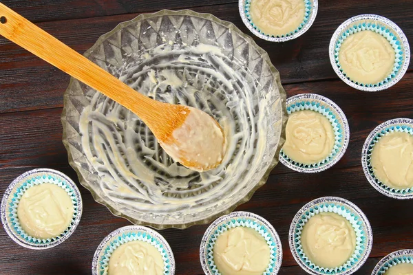 Dough in molds for muffins on a wooden table. — Stock Photo, Image