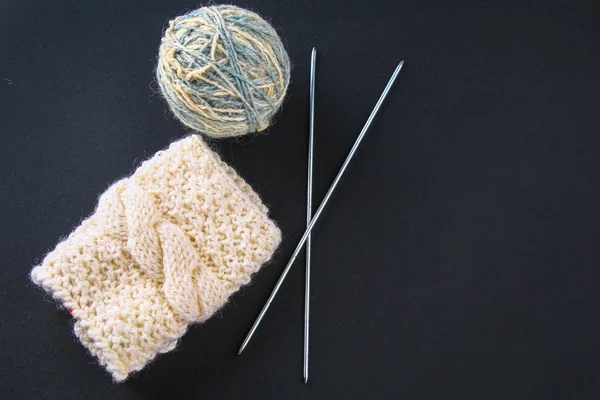 Una palla di lana con ferri da maglia e calzini su un tavolo grigio. Lavori ad ago . — Foto Stock