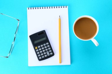 Üstten Görünüm görüntüsü açık defter ile boş sayfaları ve mavi arka plan, eklemek için hazır veya sahte kadar kahve. Natürmort, iş, ofis, banka donatımı veya eğitim kavramı.