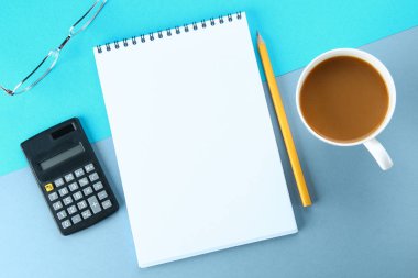 Üstten Görünüm görüntüsü açık defter ile boş sayfaları ve mavi arka plan, eklemek için hazır veya sahte kadar kahve. Natürmort, iş, ofis, banka donatımı veya eğitim kavramı.