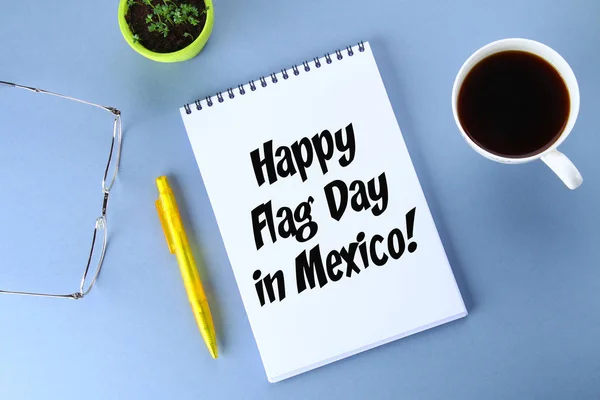 Ευτυχισμένη ημέρα της σημαίας του Μεξικού. Κείμενο σε Σημειωματάριο, στυλό, ποτήρια, καφέ, φυτό. — Φωτογραφία Αρχείου