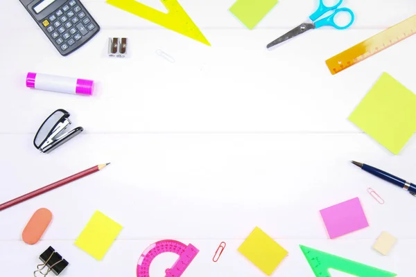 Lege ruimte omgeven door briefpapier op een witte houten tafel. Kopiëren van de ruimte. — Stockfoto