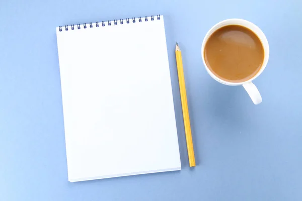 Vista dall'alto immagine di notebook aperto con pagine vuote e caffè su sfondo blu, pronto per l'aggiunta o il modello. Natura morta, affari, forniture per ufficio o concetto di istruzione . — Foto Stock