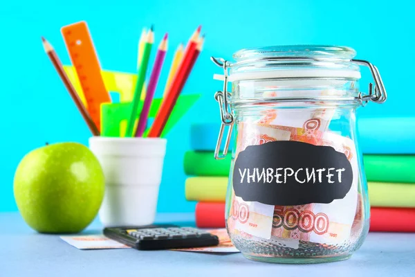 Banka Rus parası, 5000 ruble ve bir hesap makinesi, kitap üzerinde gri bir arka plan ile. Finans, servet, eğitim. Metin Rusça: üniversite.