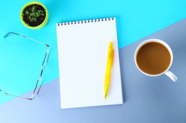 Üstten Görünüm görüntüsü açık defter ile boş sayfaları ve mavi arka plan, eklemek için hazır veya sahte kadar kahve. Natürmort, iş, ofis, banka donatımı veya eğitim kavramı.