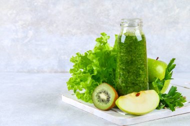 Maydanoz, salata, kivi, elma bir şişe üzerinde yeşil smoothies 