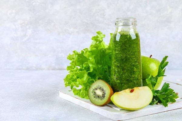Зелені коктейлі з петрушки, салату, ківі, яблука в пляшці на — стокове фото