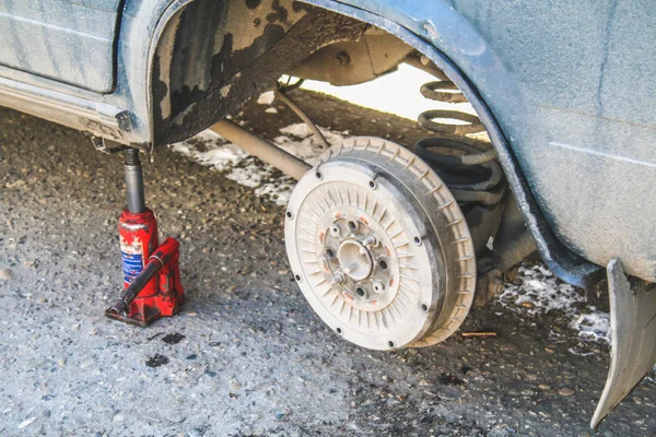 Un gato rojo levanta el coche para reemplazar la rueda perforada . —  Fotos de Stock