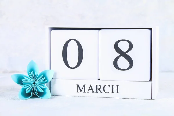 8 de marzo, Día Internacional de la Mujer. Calendario perpetuo de madera y flor de papel azul . — Foto de Stock