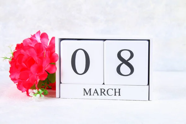 8 marca Międzynarodowy Dzień kobiet. Kalendarz wieczny drewniany i różowe kwiaty. — Zdjęcie stockowe