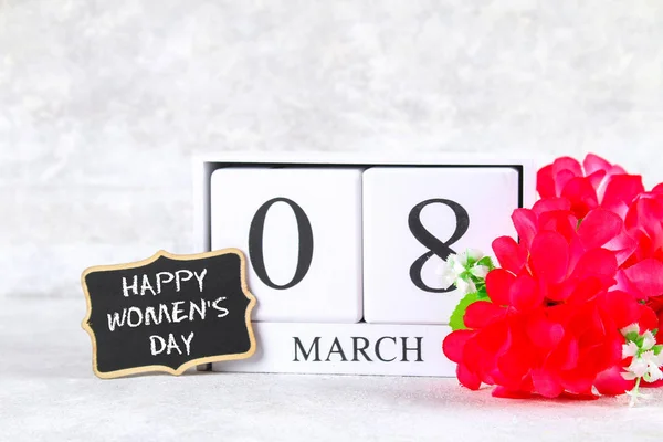 8 de março, Dia Internacional da Mulher. Calendário perpétuo de madeira, flores rosa e quadro-negro . — Fotografia de Stock